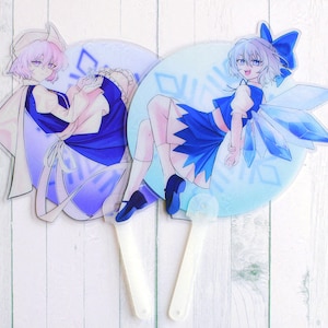 May include: Two blue and white hand fans with anime characters. The fans are made of clear plastic with a printed design. The characters are wearing blue and white outfits.