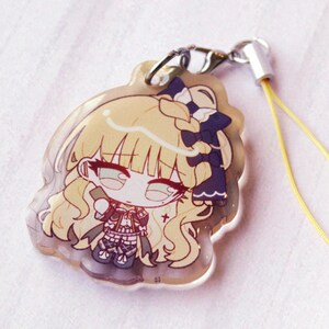 May include: A clear acrylic charm featuring a chibi-style illustration of a character with long blonde hair, a dark blue bow, and a detailed outfit. The charm includes a silver metal lobster clasp and a thin yellow cord for attachment.