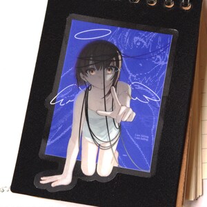 May include: A sticker featuring an anime-style illustration of a person with brown hair, a halo, and angel wings, set against a blue background with white lines. The person is reaching out. The text "I am falling" is visible.