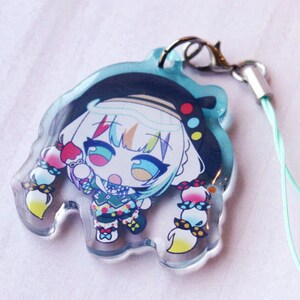 May include: A clear acrylic charm featuring a colorful anime-style character with white hair, a black beret, and multi-colored clothing. The character has large blue eyes and braided hair with red, yellow, and blue accents. Includes a silver lobster clasp.