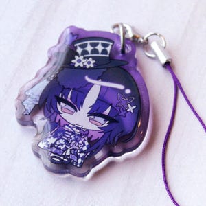 May include: A purple acrylic charm featuring a stylized anime character with dark hair, wearing a top hat with a checkered pattern and floral accents. The character has a purple outfit with a checkered skirt and is attached to a purple cord strap.