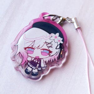 May include: A clear acrylic charm featuring a chibi-style character with white hair, pink highlights, and a black beret with a white flower. The character wears a dark purple outfit and is attached to a silver metal clasp with a light pink cord.