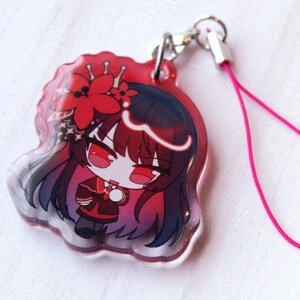 May include: A clear acrylic charm featuring a chibi-style character with long dark hair, red eyes, and a red flower hair accessory. The character wears a dark red and black outfit. A silver metal clasp and a thin pink cord are attached to the top.