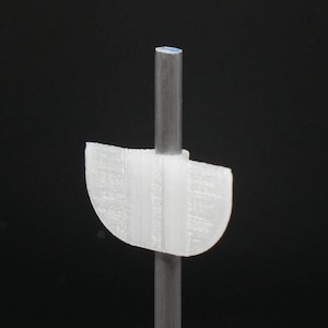 May include: A white plastic sign with a rounded top and a metal rod attached to the back. The sign is blank.