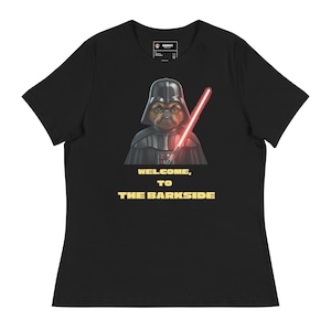 May include: Black t-shirt featuring a dog dressed as Darth Vader, holding a red lightsaber. The text "WELCOME, TO THE BARKSIDE" is printed in yellow below the image. A fun, pop culture-themed graphic tee.