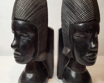 Par de sujetalibros tribales africanos antiguos tallados a mano en madera auténtica de ébano que representan figuras/bustos tradicionales, hechos en Tanganyika.