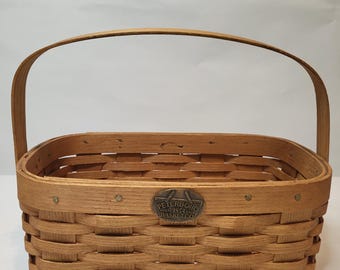 Cesto vintage da collezione in legno massello, realizzato a mano dalla Peterboro Basket Co, fondata nel 1854. Forma rettangolare con manico girevole.