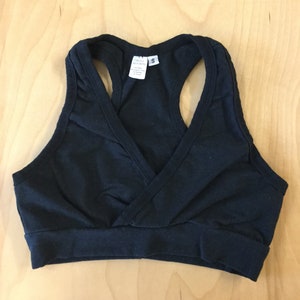 May include: Black racerback sports bra with a criss-cross front detail. The bra has a size tag that reads "Circle Sewing 5".
