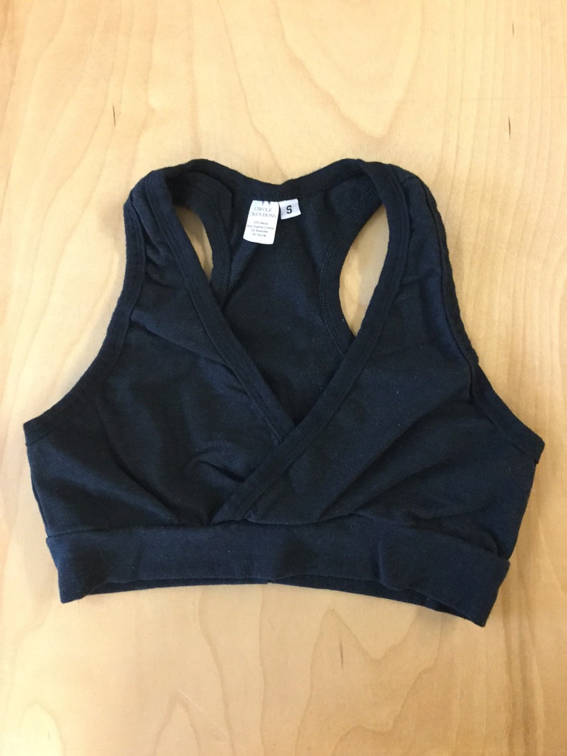 May include: Black racerback sports bra with a criss-cross front detail. The bra has a size tag that reads "Circle Sewing 5".