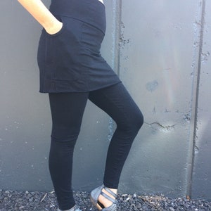 May include: A black maternity skirt with a built-in pocket and leggings. The skirt is made of a soft, stretchy fabric and is perfect for everyday wear.