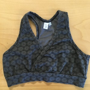 May include: A grey sports bra with a geometric pattern. The bra has a racerback style and a v-neck. The tag says "Only Hearts" and "M".