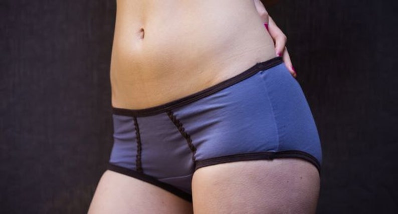 K&ouml;nnte beinhalten: Ein Paar blaue Unterw&auml;sche mit braunem Besatz. Die Unterw&auml;sche hat einen hohen Bund und einen niedrigen Bund.