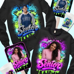 May include: Black sweatshirts, fan, and cup with a Senior design. The sweatshirts feature a photo of a person, the year 2026, and the word "Senior" in a graffiti-style font. The fan and cup have the same design.