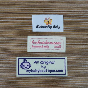 Puede incluir: Tres etiquetas rectangulares de tela con texto y gr&aacute;ficos. La etiqueta superior dice "Butterfly Baby" con un gr&aacute;fico de mariposa. La etiqueta del medio dice "herknickers.com handwash only small". La etiqueta inferior dice "An Original by mybabyboutique.com" con un beb&eacute;.