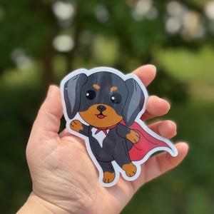 Captain Claude Sticker – Glossy Vinyl Flying Dog Hero Art, Australian Shepherd Cartoon in Red Cape