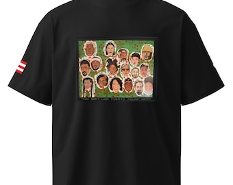 May include: Black t-shirt with a crew neck and short sleeves. The shirt features a colorful graphic of multiple faces with the text "YOU DON'T LOOK PUERTO RICAN". The left sleeve has a red and white stripe design.