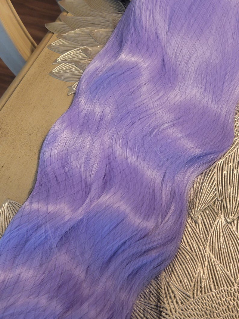Puede incluir: Una extensi&oacute;n de cabello larga y lisa en un vibrante color morado lavanda. Los mechones son suaves y uniformes, y cuentan con una fina malla superpuesta que cubre toda la longitud de la pieza para mantener su forma y alineaci&oacute;n.