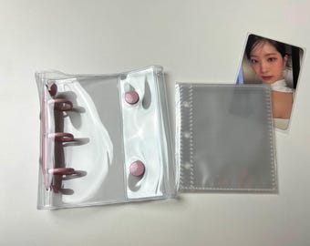 May include: Two clear plastic binder covers with pink rings and buttons. One cover is a standard size and the other is a smaller size.