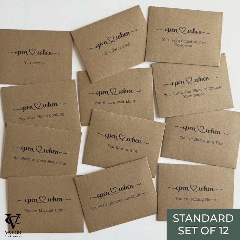 May include: A set of twelve kraft paper envelopes with the words "open when" and various prompts printed in black script. Prompts include "You Arrive," "It's Game Day," and "You Have Something to Celebrate." The set is labeled "STANDARD SET OF 12."