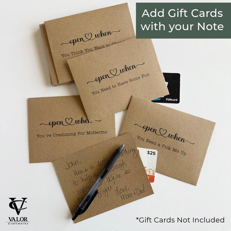 May include: Kraft paper "open when" cards with black script. The cards have phrases like "You Need to Have Some Fun" and "You're Cramming For Midterms." A pen and gift card are also visible. The text "Add Gift Cards with your Note" is in the upper right.