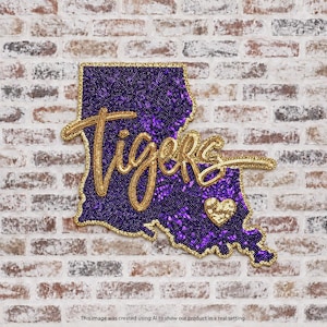 May include: A wall decoration shaped like the state of Louisiana, covered in purple sequins with a gold sequined border. The word Tigers is written in gold script across the center, accompanied by a small gold sequined heart icon.