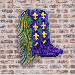 May include: A decorative patch shaped like a cowboy boot, covered in purple, green, and gold sequins. The boot features a repeating yellow fleur-de-lis pattern on a purple background, with a fringe of green and gold sequins along the side.