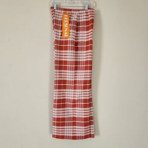 May include: Red and white plaid pants with a "PERSONAL" tag hanging from the waistband.