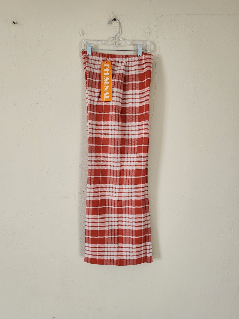 May include: Red and white plaid pants with a "PERSONAL" tag hanging from the waistband.