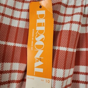 May include: Orange and white tag with the text "PERSONAL" and "DIVISION OF LESLIE FAY" in black. The tag also includes the text "WPL 11798", "SIZE 10", "100% POLYESTER", "HAND OR MACHINE WASHABLE", "9911-7", and "STYLE".