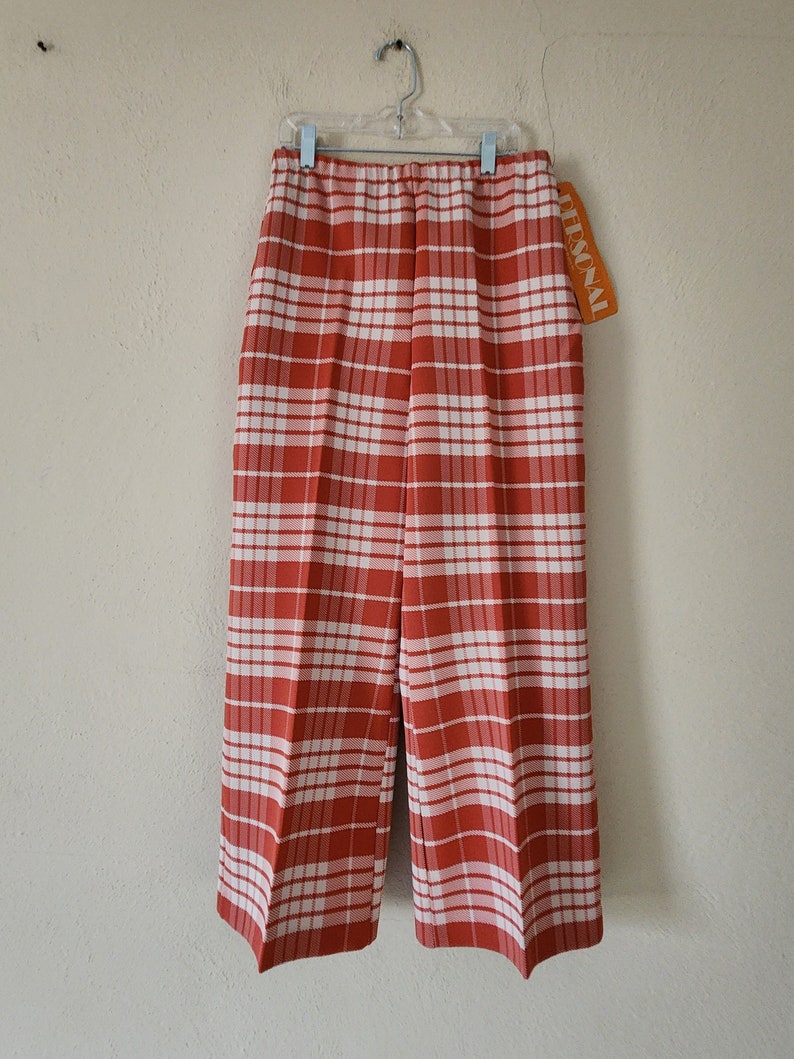 May include: Red and white plaid pants with a white elastic waistband and a "PERSONAL" tag attached.