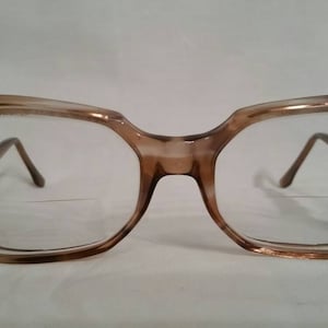 May include: A pair of brown plastic eyeglasses with octagonal frames and clear lenses.