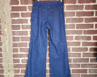 May include: A pair of blue denim bell bottom pants with a row of gold studs down the back seams.