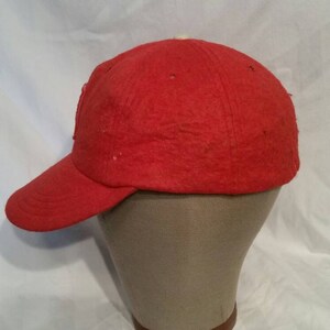 May include: A red baseball cap with a slightly curved brim. The cap is made of a soft, fuzzy material.
