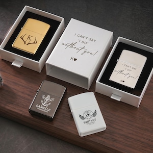 May include: A collection of personalized lighters in various colors, including gold, silver, dark gray, and white. Some lighters are engraved with initials, names, and phrases like "I can't say I do without you!" and decorative elements.