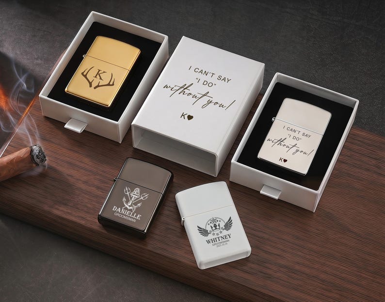 May include: A collection of personalized lighters in various colors, including gold, silver, dark gray, and white. Some lighters are engraved with initials, names, and phrases like "I can't say I do without you!" and decorative elements.