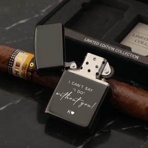 May include: A black, open lighter with the text "I CAN'T SAY 'I DO' without you!" and a heart symbol. A cigar rests beside the lighter, and the box reads "LIMITED EDITION COLLECTION".