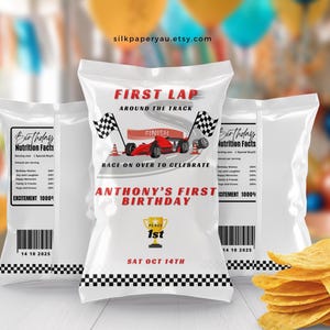 May include: White chip bags with a race car theme. The bags feature text that reads "First Lap Around the Track" and "Anthony's First Birthday." A stack of chips is in the foreground.