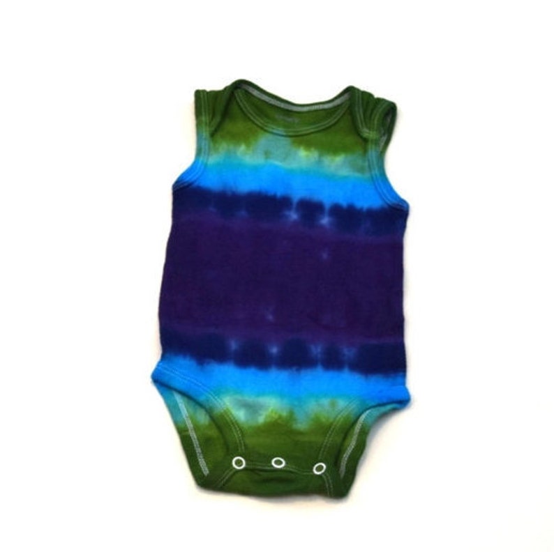 May include: A tie-dye baby onesie with green, blue, and purple stripes. The onesie has a sleeveless design and snaps at the bottom.