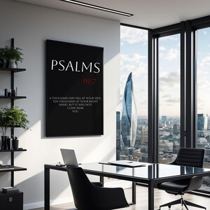May include: Black and white framed print with the text "PSALMS 91:7" and a quote from the Bible in red text. The print is hanging on a white wall in a modern office setting.