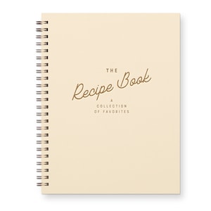 Spiral Bound Keepsake recipe book with a timeless font that reads "The Recipe Book A Collection Of Favorite." The book is Beige with brown text.