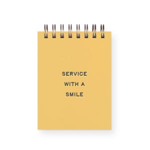 May include: A small, yellow spiral-bound notepad with the text "SERVICE WITH A SMILE" printed in black. The notepad has a clean, minimalist design, perfect for jotting down notes or reminders.