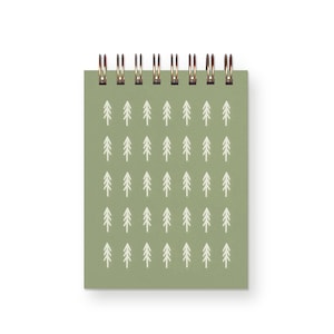 May include: A green spiral bound notebook with a white repeating pattern of stylized pine trees.