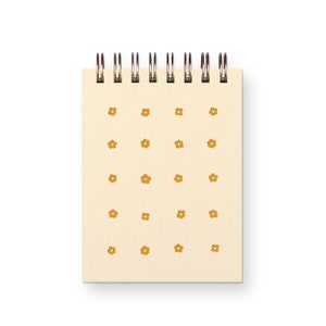 May include: A cream-colored spiral notebook with a repeating pattern of small yellow flowers.