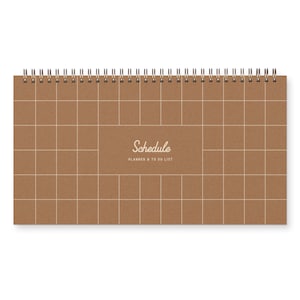May include: A brown spiral bound planner with a grid pattern and the text "Schedule Planner & To Do List" printed on the front.