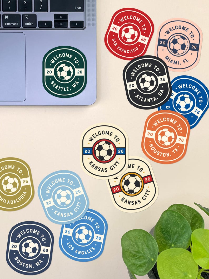 May include: A collection of colorful soccer-themed stickers with the text "WELCOME TO" and various city names, including Seattle, San Francisco, and Miami. Each sticker features a soccer ball and the numbers "20" and "26".