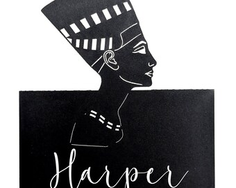 May include: Black and white illustration of a woman in profile, wearing a traditional headdress. The image features the name "Harper" in a cursive font at the bottom, set against a black rectangular background.