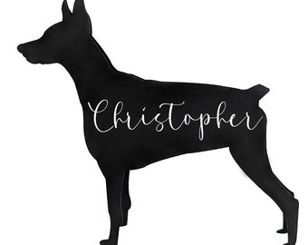 May include: A black silhouette of a dog in a standing pose, with the name "Christopher" written in cursive across its body. The dog has pointed ears and a short tail, set against a white background.