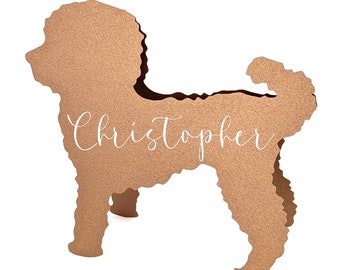 May include: A brown, textured dog-shaped cutout with the name "Christopher" in white script. The cutout is standing on a white background. The dog's silhouette is detailed, with visible legs and tail.