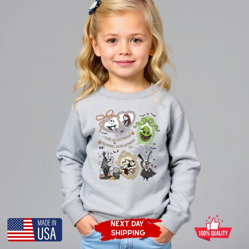 Może przedstawiać: Jasnoszara bluza z nadrukiem postaci z filmu The Nightmare Before Christmas w ramkach. Ramki zawierają Jacka Skellingtona, Sally, Oogie Boogie i inne postacie. Wyprodukowano w USA.