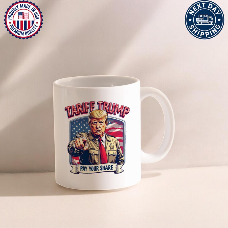 May include: White ceramic coffee mug with a graphic of Donald Trump in a sheriff's uniform with the text "Tariff Trump" and "Pay Your Share" printed on it.